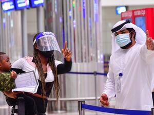A tourist receives instruction at Dubai airport in the United Arab Emirates on July 8, 2020, as the country reopened its doors to international visitors in the hope of reviving its tourism industry after a nearly four-month closure. GIUSEPPE CACACE / AFP