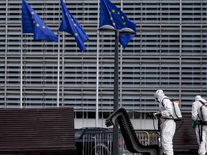 Men disinfect benches in Brussels on July 10, 2020 in front of the European institutions. Kenzo TRIBOUILLARD / AFP