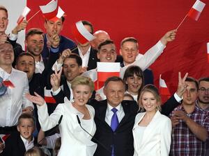 Polish President Andrzej Duda flashes V-signs after addressing supporters with his wife Agata as exit poll results were announced during the presidential election in Pultusk, Poland, on July 12, 2020. Poland's right-wing head of state Andrzej Duda was ahead by a tiny margin in the presidential run-off against Warsaw's liberal mayor, an exit poll on on July 12, 2020 showed, starting a tense wait for the official results JANEK SKARZYNSKI / AFP