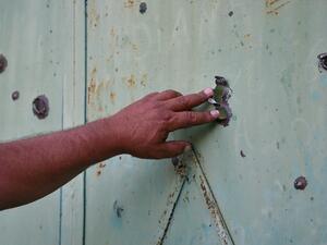 A resident shows the gate of a house in the village of Aygepar in Tavush region damaged by recent shelling during armed clashes on the Armenian-Azerbaijani border on July 15, 2020. Defence officials in Armenia and Azerbaijan said fighting on their border subsided on July 15, 2020 after several days of deadly clashes raised fears of a major flare-up. At least 16 people on both sides were killed in three days of shelling that started Sunday between the ex-Soviet republics, which have been locked for decades i