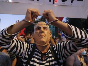 An Israeli protester dressed as a prisoner dons a mask representing Prime Minister Benjamin Netanyahu during an anti-government demonstration outside Netanyahu's official residence in Jerusalem, on July 18, 2020. Ahmad GHARABLI / AFP