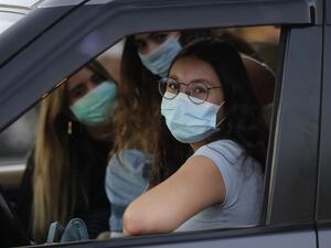 Lebanese women wearing protective masks amid the COVID-19 pandemic wait in their car to watch a movie at a drive-in cinema at a park in the coastal town of Byblos, north of the capital on July 18, 2020. A group of Lebanese university graduates launched a drive-in cinema, as movie theatres remain closed due to the novel coronavirus pandemic. The income of the drive-in cinema will go to needy families to help deal with the country's economic crisis. JOSEPH EID / AFP