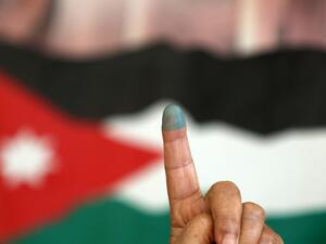 A Jordanian woman shows her ink-stained finger after voting Tuesday morning in the parliamentary elections. (AFP/Khalil Mazraawi)