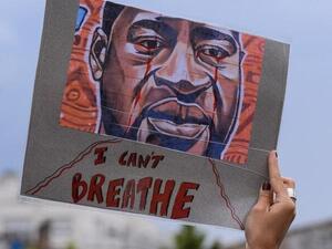 A woman holds a placard depicting George Floyd's face and reading "I can't breathe" in Bordeaux, on June 9, 2020. (AFP)
