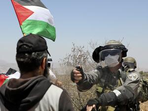 An Israeli border guard sprays pepper spray towards a Palestinian demonstrator during a protest against Jewish settlements and Israel's planned annexation of parts of the Israeli-occupied West Bank, in the town of Asira Shamaliya near the West Bank city of Nablus on July 17, 2020. JAAFAR ASHTIYEH / AFP
