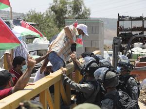 Israeli border guards stop a Palestinian demonstrator from crossing a barrier during a rally to protest Israel's plan to annex parts of the occupied West Bank, in the Palestinian village of Haris, southwest of Nablus, on July 24, 2020. JAAFAR ASHTIYEH / AFP