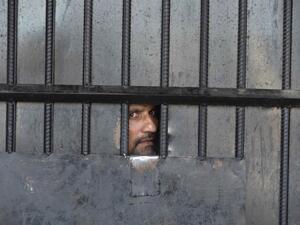 In this picture taken on August 3, 2020, an inmate watches from behind a closed gate after a raid at the prison in Jalalabad. At least 29 people were killed when gunmen attacked a jail in the eastern city of Jalalabad on August 3, shattering the relative calm of the final day of a three-day ceasefire between the Taliban and Afghan forces. NOORULLAH SHIRZADA / AFP