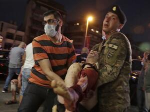 A Lebanese army soldier and a man carry away an injured man at a hospital in the aftermath of an explosion at the port of Lebanon's capital Beirut on August 4, 2020. Two huge explosion rocked the Lebanese capital Beirut, wounding dozens of people, shaking buildings and sending huge plumes of smoke billowing into the sky. Lebanese media carried images of people trapped under rubble, some bloodied, after the massive explosions, the cause of which was not immediately known. IBRAHIM AMRO / AFP