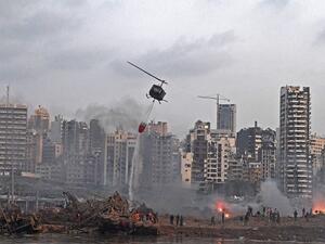 A helicopter try to put out multiple fires at the scene of the massive explosion that hit Beirut's port on August 4, 2020 in the heart of the Lebanese capital. Rescuers searched for survivors in Beirut on August 5 after a cataclysmic explosion at the port sowed devastation across entire neighbourhoods, killing more than 100 people, wounding thousands and plunging Lebanon deeper into crisis. AFP
