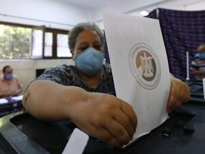 An Egyptian woman, mask-clad due to the COVID-19 coronavirus pandemic, casts her vote at polling station on August 11, 2020 for a new senate in an upper house election. The two-day vote for 200 of the Senate's 300 seats will be largely contested by candidates who back President Abdel Fattah al-Sisi, who has quietened most opposition within and outside the legislature.  Khaled DESOUKI / AFP
