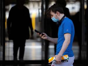 A face mask-clad pedestrian walks in Wellington's central business district in on August 12, 2020. New Zealand's dream run of 102 days without locally transmitted coronavirus ended on August 11, prompting a stay-at-home lockdown order for the country's largest city. Marty MELVILLE / AFP
