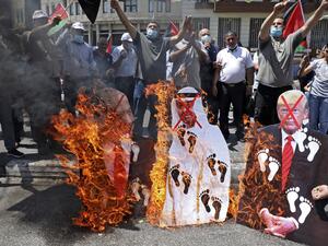 Palestinian protesters set aflame cut-outs showing the faces of (L to R) Israeli Prime Minister Benjamin Netanyahu, Abu Dhabi Crown Prince Sheikh Mohammed bin Zayed al-Nahyan, and US President Donald Trump, during a demonstration in Nablus in the occupied West Bank on August 14, 2020 against a US-brokered deal between Israel and the UAE to normalise relations. The deal marks only the third such accord the Jewish state has struck with an Arab nation, an historic shift making the Gulf state only the third Ara