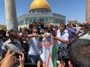 A grab from a AFPTV video shows Palestinian protesters tearing apart a portrait of Abu Dhabi Crown Prince Sheikh Mohammed bin Zayed al-Nahyan on August 14, 2020 at the al-Aqsa mosque compound in Jerusalem, during a protest against a US-brokered deal between Israel and the UAE to normalise relations. AFPTV / AFP