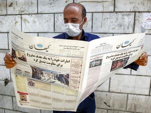 A man, clad in mask due to COVID-19 coronavirus pandemic, reads a copy of the Kayhan newspaper, considered to be the mouthpiece of ultraconservatives in Iran, with a headline on its front page reading in Farsi "the UAE has become legitimate and easy target for the resistance", while standing by a newspaper stall in Iran's capital Tehran on August 15, 2020. AFP