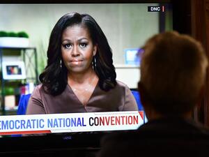 A person watches former First Lady Michelle Obama speak during the opening night of the Democratic National Convention, being held virtually amid the novel coronavirus pandemic, in Los Angeles, on August 17, 2020. America's political convention season begins tonight with former first lady Michelle Obama addressing the Democrats' now-virtual gathering set to anoint Joe Biden, as President Donald Trump defies coronavirus concerns to rally supporters in battleground Wisconsin. Chris Delmas / AFP