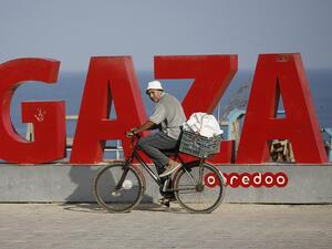 A Palestinian man rides a bicycle on the Gaza beachfront early on August 25, 2020, as a 48-hour total lockdown is declared in the Strip following the discovery of local cases of the novel coronavirus. MOHAMMED ABED / AFP