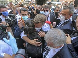 A Lebanese youth hugs French President Emmanuel Macron during a visit to the Gemmayzeh neighbourhood, which has suffered extensive damage due to a massive explosion in the Lebanese capital. AFP