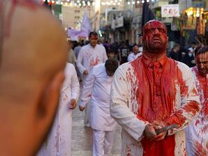 Iraqi Shiite Muslim worshippers are covered with blood after flagellating themselves during the mourning procession on the tenth day of Muharram which marks the day of Ashura, in the Iraqi holy city of Najaf (AFP)