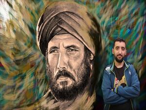Shams El Din Belarbi in front of one of his hand-painted posters (Facebook)