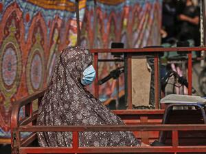 A Palestinian woman, working in the public sector, sits in the back of a truck in Gaza City on September 1, 2020, amid a lockdown due to increasing cases of COVID-19 infections. MAHMUD HAMS / AFP