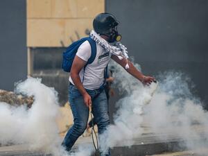 A protester uses a badminton racket to serve back a tear gas canister during clashes with security forces amidst an anti-government demonstration in the centre of Lebanon's capital Beirut during on September 1, 2020. AFP