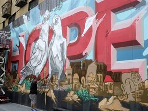 Artists from the group REK paint a mural on a barrier erected in front of Le Grey hotel in Beirut's downtown district, depicting the city with the word "HOPE" inscribed on it, on September 4, 2020, one month after the August 4 massive blast at the nearby seaport that left scores of people dead or injured ravaged swaths of the Lebanese capital. JOSEPH EID / AFP