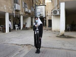 Ultra-Orthodox Jewish men, wearing a protective face masks due to the COVID-19 coronavirus pandemic and "Talit" prayer shawl, keep a two-metre distance as they pray along a street outside a synagogue in the ultra-Orthodox city of Bnei Brak, near Tel Aviv on September 6, 2020. Israel, next week, is expected to impose a new lockdown over some ten cities following the spread of the Coronavirus disease. MENAHEM KAHANA / AFP
