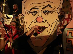 Israeli protesters carry a board with a caricature of their prime minister during an anti-government demonstration in front of Netanyahu's residence in Jerusalem on September 12 2020, demanding that he resign over several corruption indictments and his handling of the coronavirus crisis menahem kahana / AFP