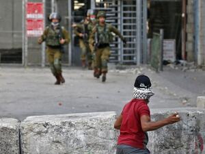 A Palestinian protester hurls stones at Israeli security forces amid clashes in the center of the West Bank city of Hebron, on September 18, 2020. HAZEM BADER / AFP