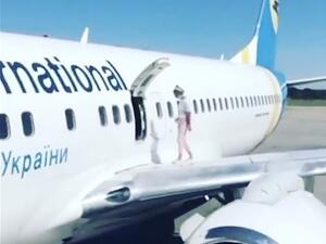 A woman climbed on to the wing of a plane after landing in Kyiv on a flight from Antalya, bizarre video footage shows (Instagram)