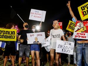 Israeli protesters wave national flags and chant slogans against the government near the prime minister's residence in Jerusalem. (AFP) Israeli protesters wave national flags and chant slogans against the government near the prime minister's residence in Jerusalem. (AFP)
