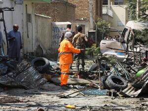 Afghan security personnel inspect the site of an explosion targeting Amrullah Saleh's convoy. (AFP)