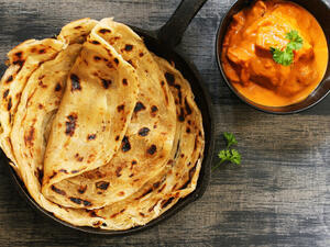 Homemade Kerala wheat paratha or layered parotta / flat bread served with Paneer curry (Shutterstock)