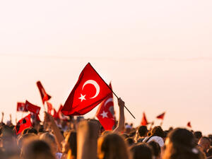 Crowded people in the square of Gundogdu and Turkish flags in crowded people  (Shutterstock)	
