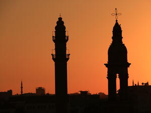A minaret and bell tower silhouette (Shutterstock/ File Photo)