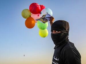 Masked Palestinians of the Popular Resistance Committees prepare to release balloons carrying slogans towards Israel, near Rafah, along the southern border between the Gaza Strip and Israel, on September 28, 2020 on the 21st anniversary of the group. SAID KHATIB / AFP