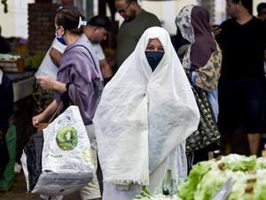 A woman clad in veil and face mask due to the COVID-19 coronavirus pandemic walks at the central market in Tunisia's capital Tunis on October 4, 2020. (AFP/File)