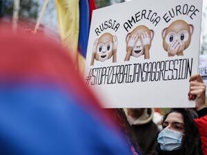 A member of the Belgian Armenian community hold a placard as they gather to protest against the conflict between Azerbaijan and Armenia over Nagorno-Karabakh, near the European Commission headquarters in Brussels, on October 7, 2020. Kenzo TRIBOUILLARD / AFP