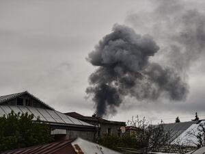 Smoke rises behind houses after shelling in the breakaway Nagorno-Karabakh region's main city of Stepanakert on October 7, 2020, during the ongoing fighting between Armenia and Azerbaijan over the disputed region. ARIS MESSINIS / AFP