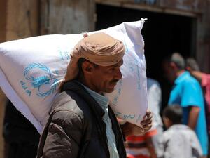 A Yemeni man receives humanitarian aid, donated by the World Food Programme (WFP), in the country's third city of Taez, on October 10, 2020. AHMAD AL-BASHA / AFP
