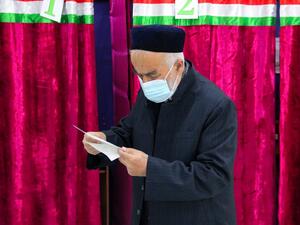 A man looks through his ballot at a polling station during Tajikistan's presidential election in Dushanbe on October 11, 2020, amid the ongoing coronavirus disease pandemic. STRINGER / AFP