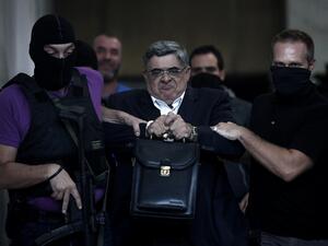  In this file photo taken on September 28, 2013 the leader of ultra-right wing Golden Dawn party Nikos Michaloliakos is escorted by masked police officers to the prosecutor from the police headquarters in Athens. A Greek court on October 14, 2020 handed a 13-year prison sentence to the leader of neo-Nazi group Golden Dawn for running a criminal organisation. As well as Nikos Michaloliakos, the party's founder -- who received an additional one year for illegal possession of a weapon -- the court also sentenc