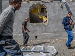 Men pass in front of a house destroyed by shellings in the village of Bakharly, near Agdam city during the ongoing fighting between Armenia and Azerbaijan over the disputed region, in the city of Terter on October 14, 2020. Azerbaijan said on October 14, 2020 it had destroyed missile launchers inside Armenia that were targetting its cities, as fierce fighting over Nagorno-Karabakh risked widening beyond the disputed region. Hundreds have already lost their lives in two weeks of fighting, and continued clash