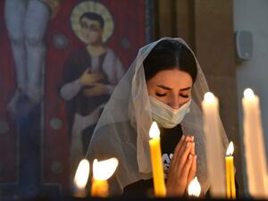 An Armenian woman, wearing a face mask, prays in a church in Yerevan on October 17, 2020, for Armenians killed during fighting over the breakaway region of Nagorno-Karabakh. Baku and Yerevan have for decades been locked in a simmering conflict over Nagorno-Karabakh, an ethnically Armenian region of Azerbaijan which broke away from Baku in a 1990s war that claimed the lives of some 30,000 people. The Caucasus neighbours have defied international calls to halt hostilities and accused the other of starting new