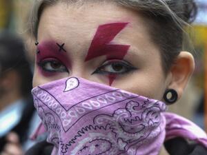 A woman sports a lightning bolt painted over her eyes as she attends a demonstration against the tightening of Poland's already restrictive abortion law on October 28, 2020 in Warsaw. Women in Poland walked off the job and hit the streets nationwide on October 28, 2020, the seventh straight day of mass protests over a court ruling to impose a near-total abortion ban in Poland. JANEK SKARZYNSKI / AFP