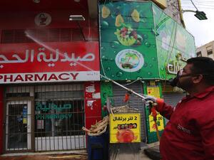 A municipality worker disinfects a pharmacy in the Jordanian capital Amman as part of preventive measures against the spread of the coronavirus, on March 21, 2020. Photo by Photo by KHALIL MAZRAAWI/AFP via Getty Images.