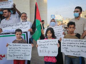 Palestinian demonstrators lift placards protesting the Sudan normalisation agreement with Israel, in Rafah town in the southern Gaza Strip on October 24, 2020. Sudan and Israel agreed on October 23 to normalise relations, in a US-brokered deal to end decades of hostility that was widely welcomed but stirred Palestinian anger. SAID KHATIB / AFP