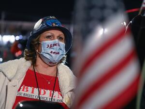 A supporter of Democratic presidential nominee and former Vice President Joe Biden looks at partial election results on a giant screen outside the Chase Center in Wilmington, Delaware on November 3, 2020. ROBERTO SCHMIDT / AFP