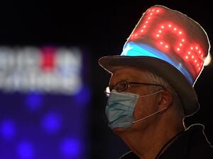 A supporter of Democratic presidential nominee and former Vice President Joe Biden looks at partial election results on a giant screen outside the Chase Center in Wilmington, Delaware on the early hours of November 4, 2020. Roberto SCHMIDT / AFP
