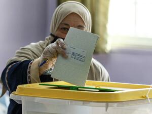 A voter, mask-clad due to the COVID-19 coronavirus pandemic, casts her ballot at a polling station in Jordan's capital Amman on November 10, 2020, during the 2020 general election. (AFP/File Photo)